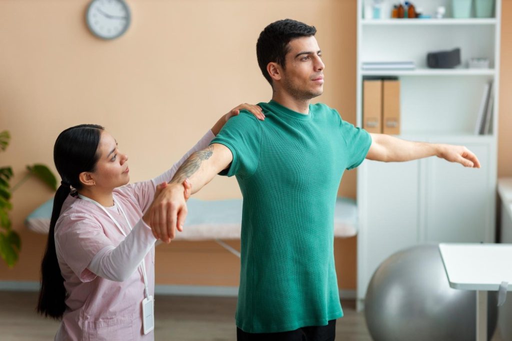 Chiropractor guiding a patient through gentle exercise to support recovery and movement improvement