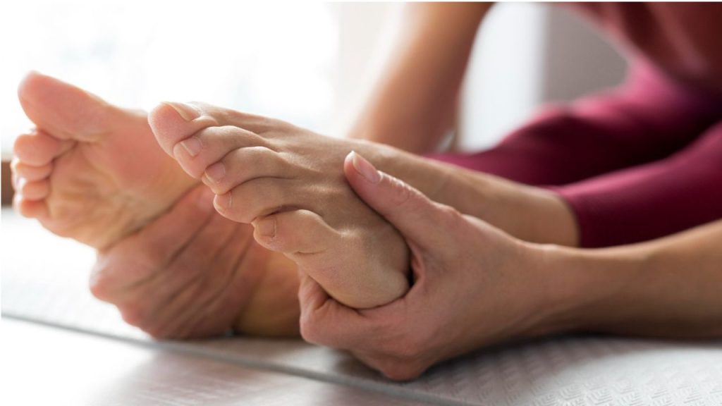 Close-up of legs and hands stretching on a mat