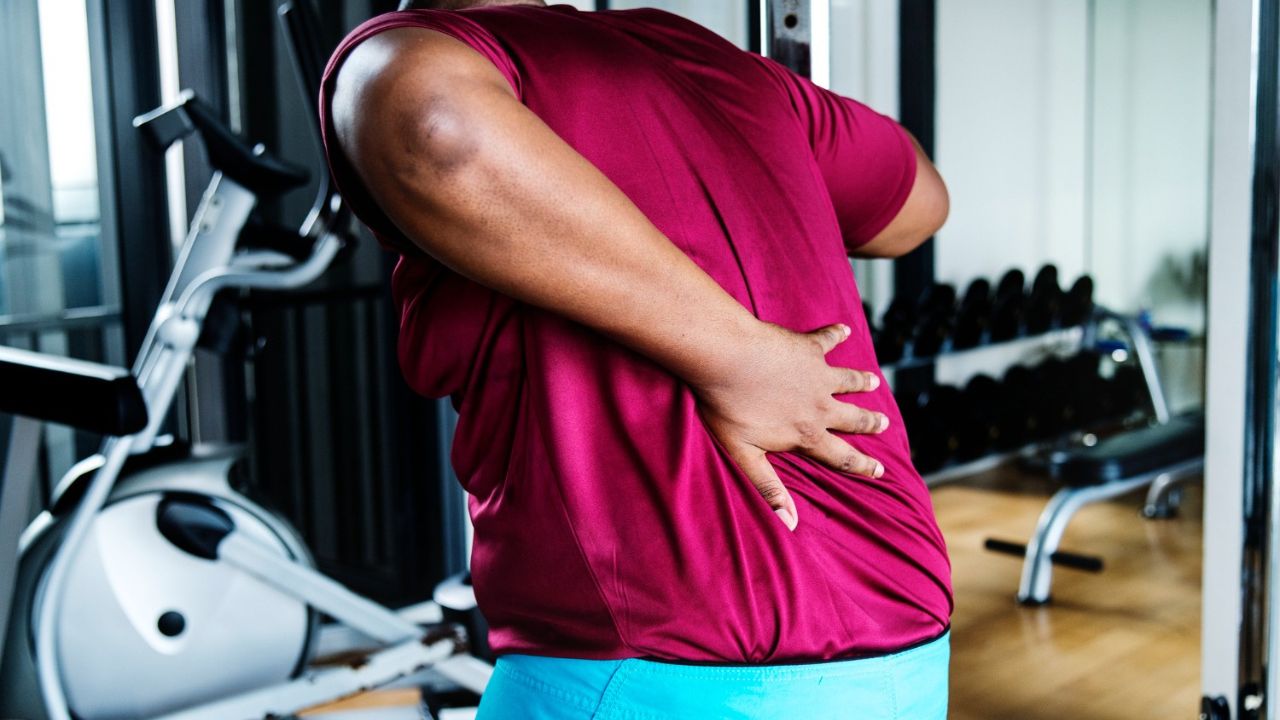 Man holding lower back in pain due to herniated disc