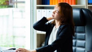 Woman working on the PC with neck pain and discomfort