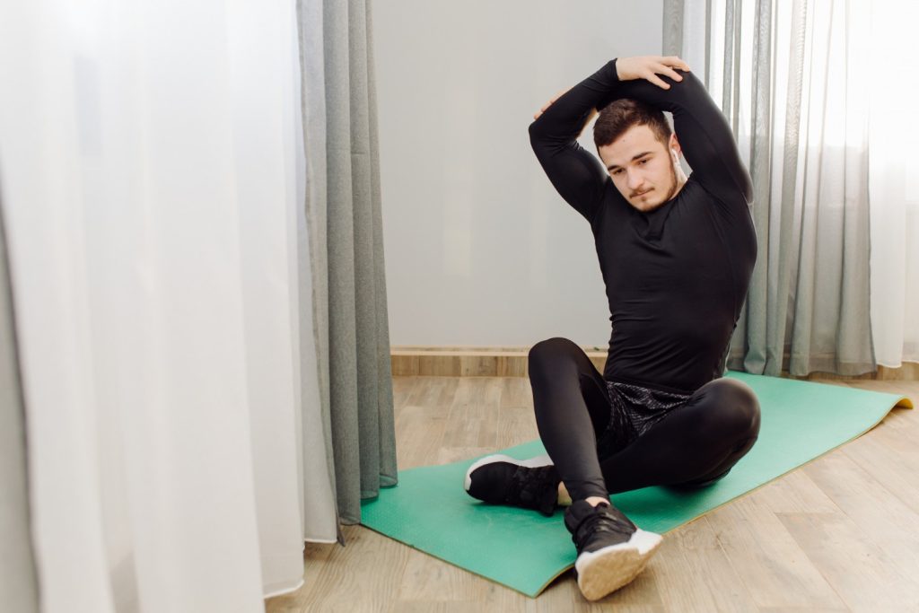 Young man performing home workout exercises with proper form in a home setting 
