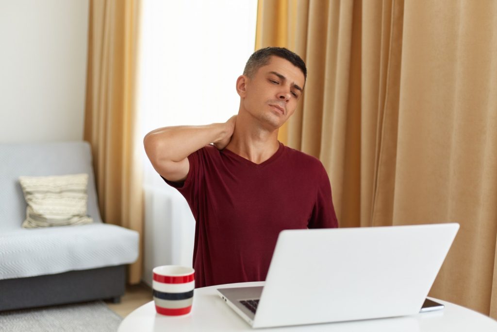 man on a laptop having neck pain due to poor posture