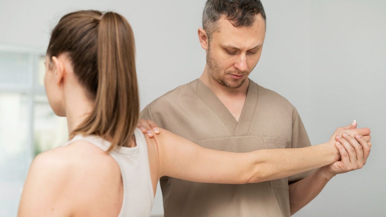 Healthcare professional Kelowna Chiropractor evaluating and examining a patient’s shoulder during a clinical assessment