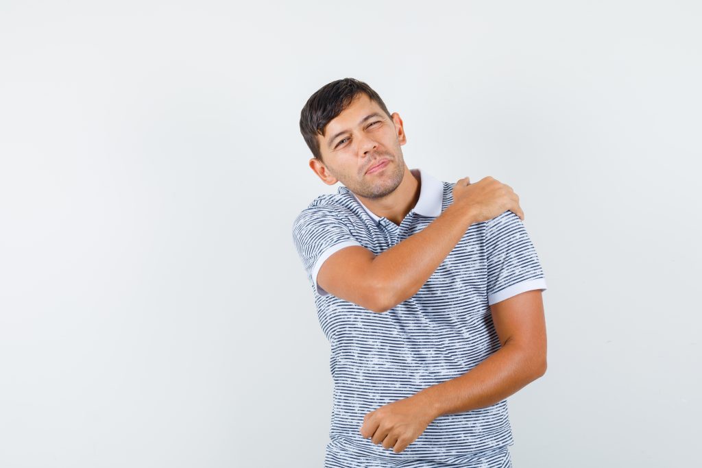 Young male suffering from shoulder pain
