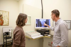 Chiropractor discussing health and assessment findings with a patient