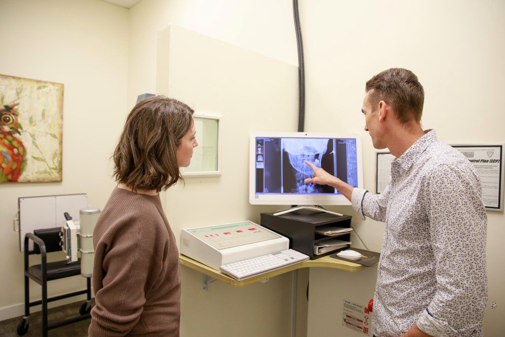 Chiropractor discussing treatment results with a patient during a consultation at the clinic