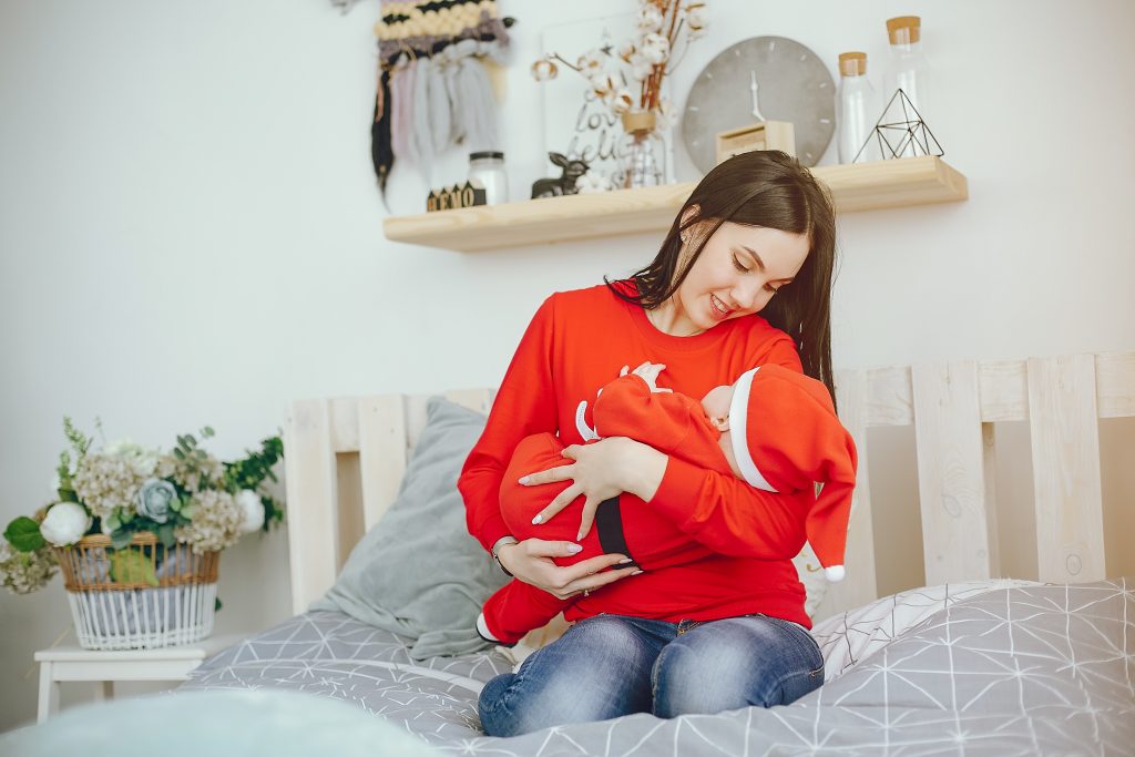 Woman gently holding her baby in her arms with a calm, caring expression
