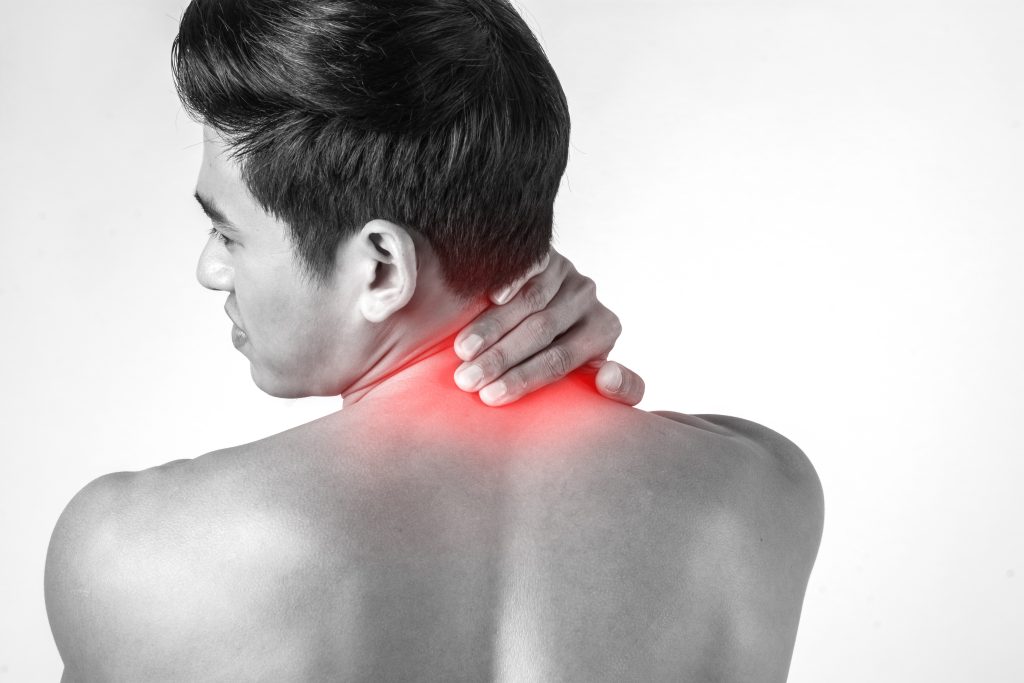 Muscular man use handles at the neck to relieve pain isolated on