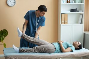 Chiropractor assisting a patient during rehabilitation treatment.