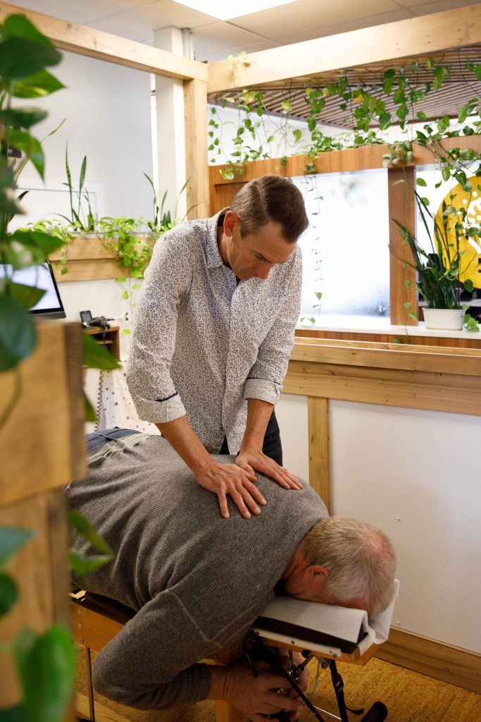 Chiropractor providing rehabilitation therapy to improve mobility and posture.