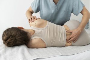 Chiropractor performing a lower back adjustment on a female patient.