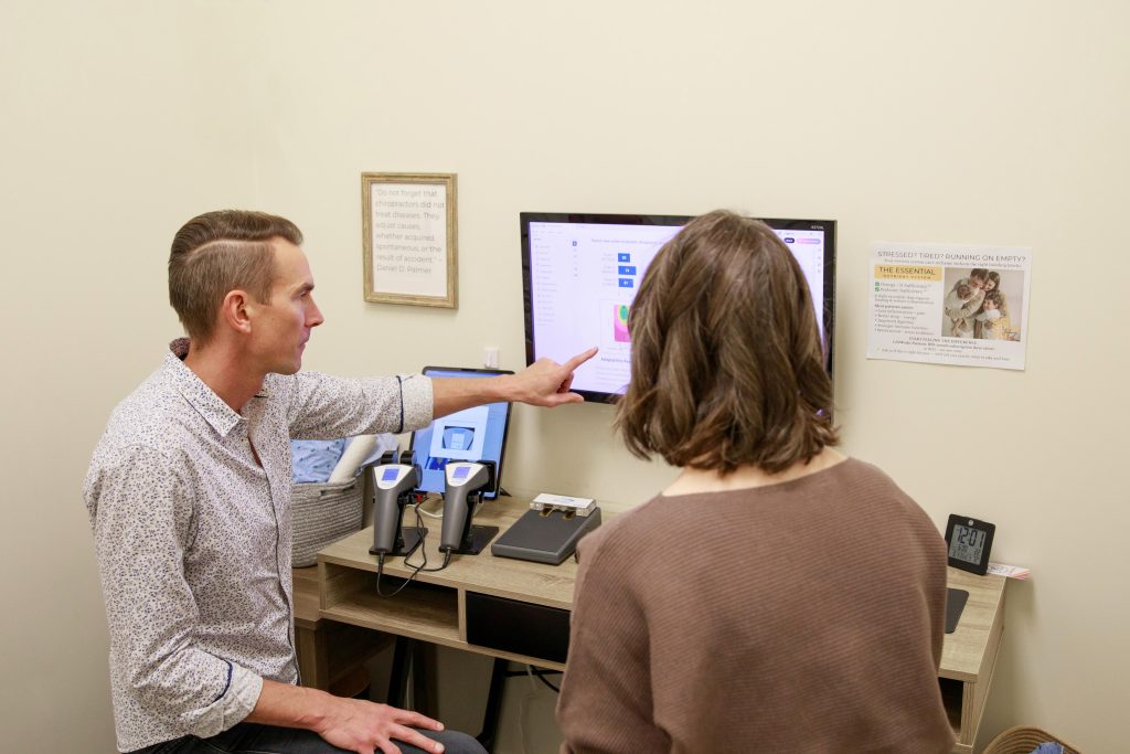 Chiropractor reviewing diagnostic reports and patient test results.